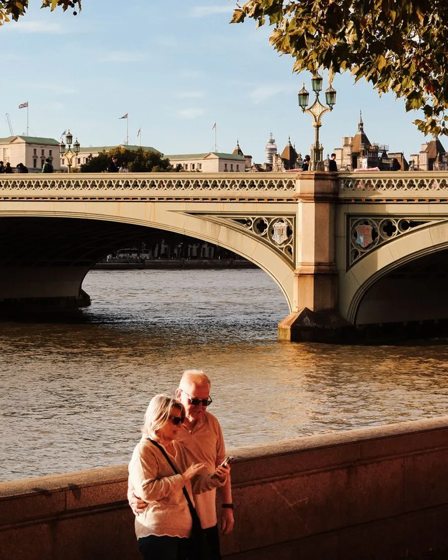 An older couple by the Thames in front of Westminster Bridge, London
