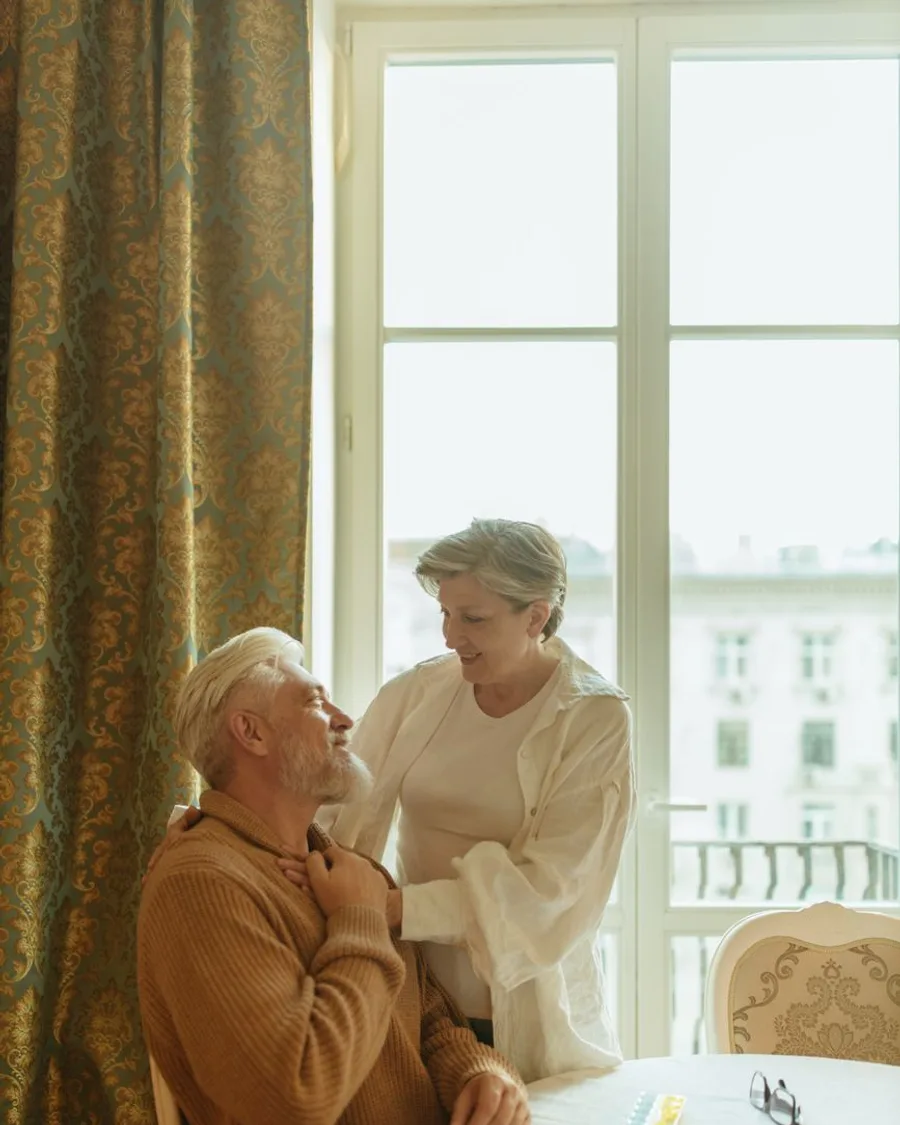 An older couple by a bright window