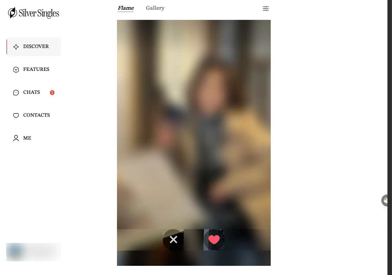 A Flame card on the SilverSingles web version. The member's photo, name, age and town are blurred by us. Under the card are a round X button on the left and a round heart button on the right.